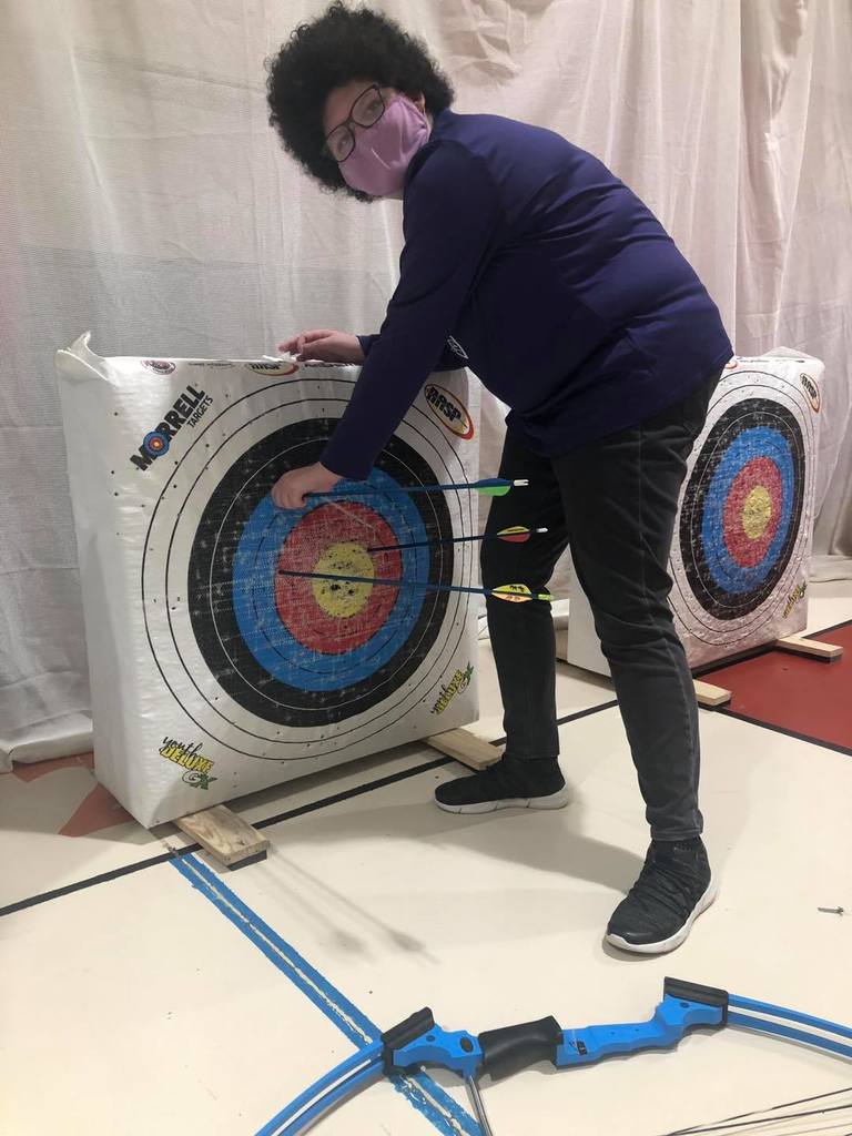Student pulling out bows from bullseye